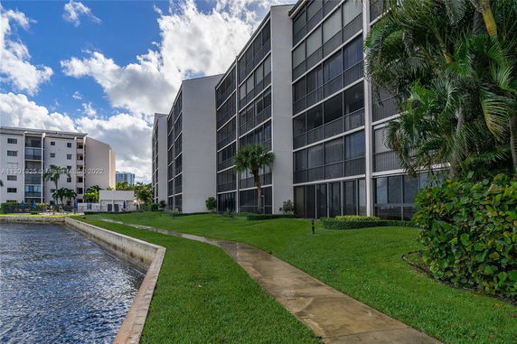 Front view of a multi-story apartment building near a waterfront.