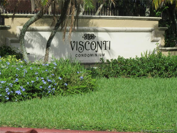 Sign reading 'Visconti Condominium' with surrounding plants.