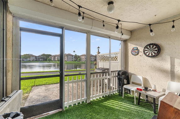 Outdoor patio area with a view of a lake and distant buildings.