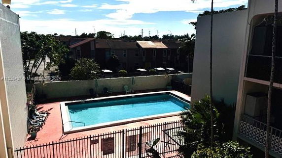 View of an outdoor swimming pool surrounded by buildings.