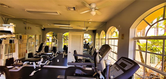 Indoor fitness area with exercise machines and mirrors.