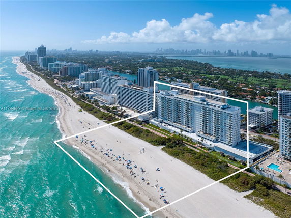 Panoramic view of beachfront high-rise buildings with marked property boundaries and ocean.