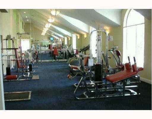 Gym area with various exercise equipment inside a building.