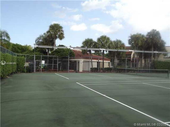 Tennis court surrounded by trees and buildings