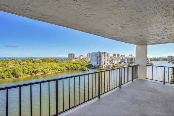 Balcony view overlooking water and city skyline.