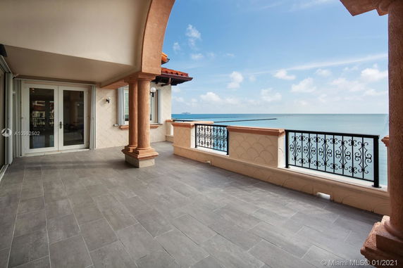 Outdoor terrace area with tiled flooring and ocean view.