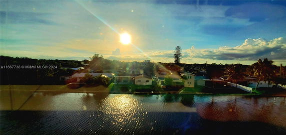 View of residential houses near a body of water during sunset.