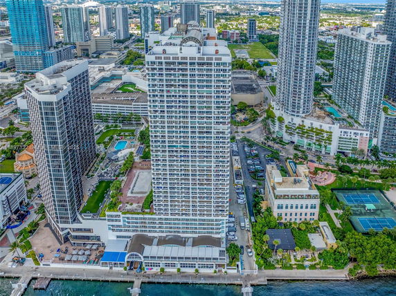 Elevated view of a tall residential building surrounded by other towers and cityscape.