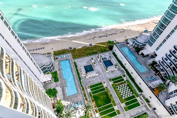 Elevated view of a beachside area with pools and patios.