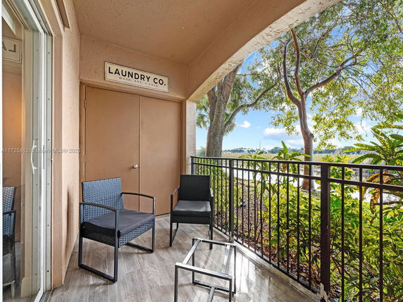 Outdoor balcony with chairs overlooking leafy surroundings.