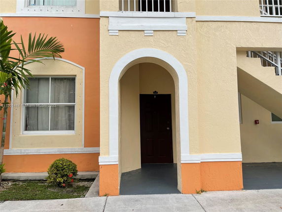 Front view of a building entrance with an archway and stairs.