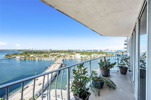 Balcony view overlooking a bridge and surrounding water and city landscape.