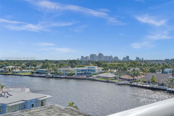 Panoramic view of waterfront properties with a city skyline in the distance.