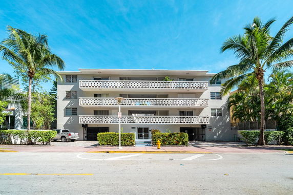 Front view of a multi-story building with a decorative balcony facade.