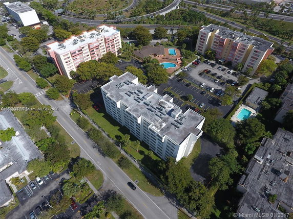 Aerial view of multiple multi-story apartment buildings with parking areas and swimming pools.