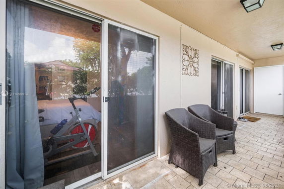 Patio area of a house with sliding glass doors and wicker chairs