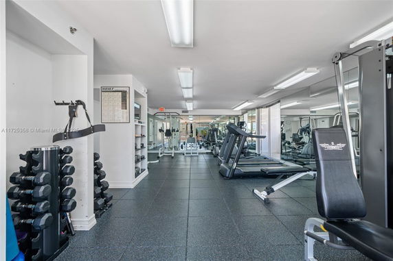 Interior view of a gym with exercise equipment and mirrors.