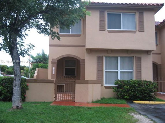 Front view of a two-story house with a small gated entrance.