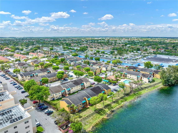Panoramic view of residential area with houses, roads, and a lake.