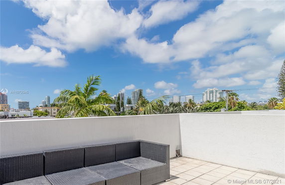 Outdoor terrace with cityscape view and seating area.