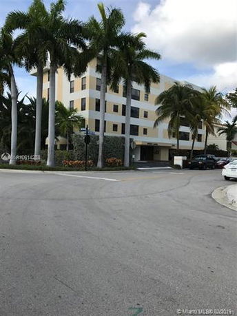 Front view of a multi-story building with palm trees