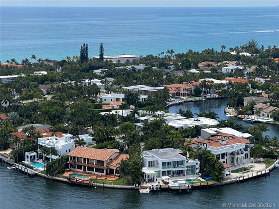 Wide angle view of coastal homes along a waterway with ocean in the background.