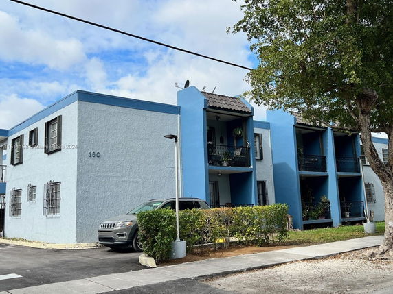 Front view of a two-story apartment building with blue and white exterior.