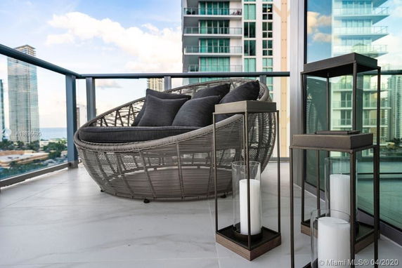 Balcony view with modern seating and skyscrapers in the background.