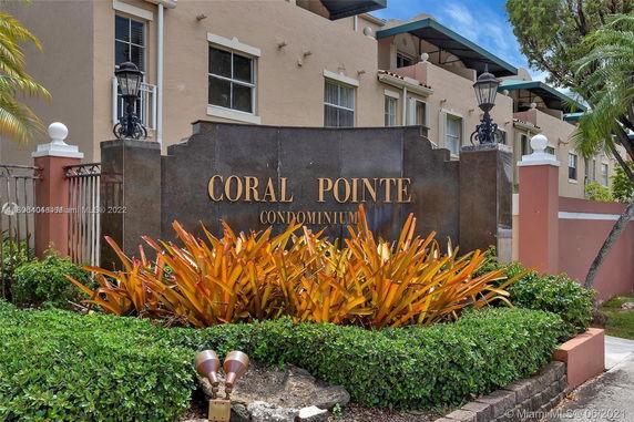 Front view of a condominium building with a sign reading 'Coral Pointe.'