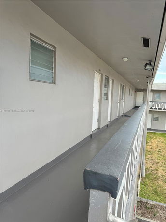 View of the exterior walkway of a building's upper floor.