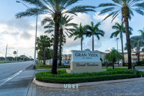 Entrance sign for Gran Vista at Doral with palm trees and a road.