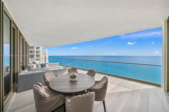 Balcony view with outdoor seating overlooking the ocean.