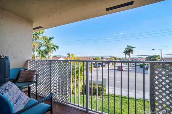 View from a balcony overlooking a street and palm trees