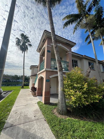 Front view of a two-story house with a balcony and a walkway.