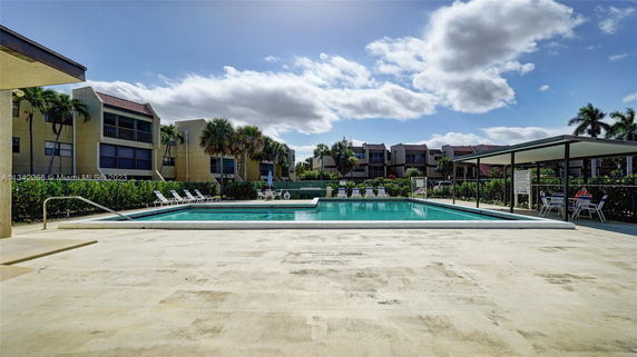 Outdoor swimming pool area with surrounding apartment buildings.