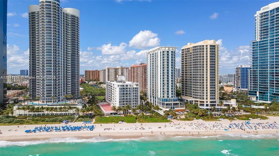 Beachfront view of multiple tall residential buildings along the shoreline.