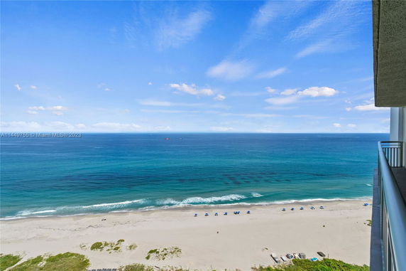 Panoramic view of the ocean and beach from a building balcony.
