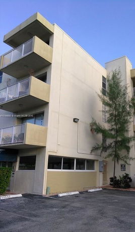 Corner view of a multi-story building with balconies.