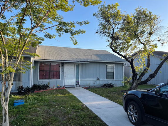 Front view of a single-story house with a gable roof and white front door.