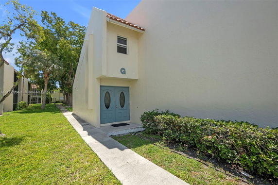 Front view of a building with a double door entrance and a small window above.