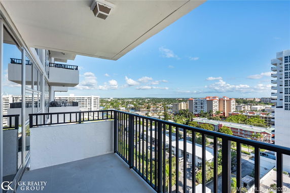 View from a balcony overlooking a cityscape with multiple residential buildings.