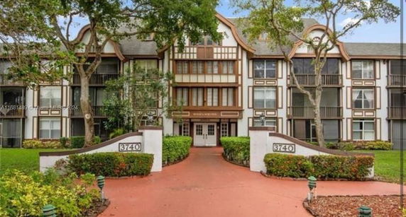 Front view of a multi-story building with Tudor-style architecture and entrance pathway.