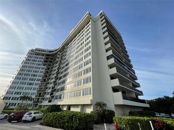 Front view of a multi-story building with balconies and large windows.