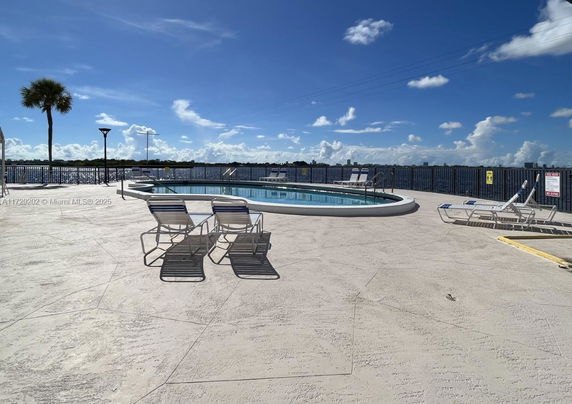 Outdoor area with a swimming pool and lounge chairs overlooking a scenic view.