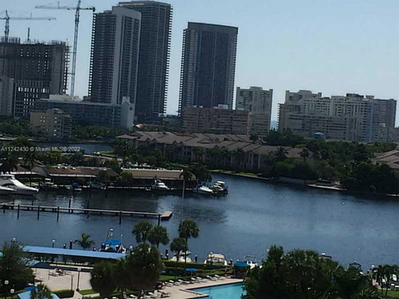 View of high-rise buildings near a waterfront with boats, seen from a higher vantage point.