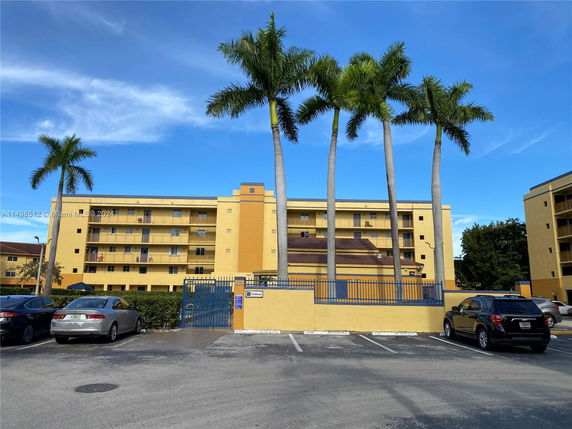 Front view of a multi-story apartment building with balconies.
