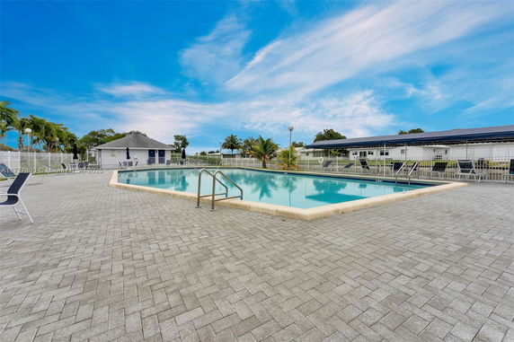 Outdoor swimming pool area with surrounding patio and lounge chairs.