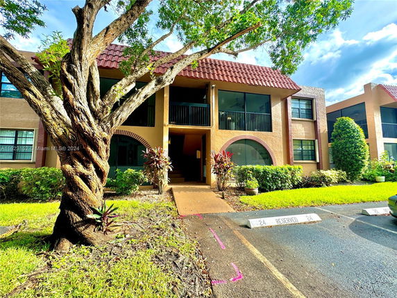 Front view of a two-story residential building with a red-tiled roof and balconies.