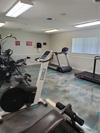 Indoor gym area with exercise equipment including treadmills and bikes.