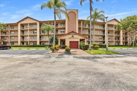 Front view of a four-story apartment building with covered entrance.